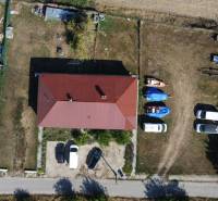 Aerial view of a family house in Zemianska Olča with a spacious yard and parked cars.