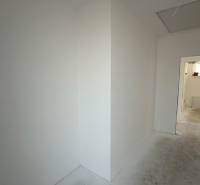 The interior of a family house with white walls and a dirty floor.