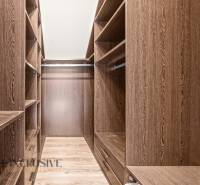 A wardrobe with a wooden decor and storage shelves in a family house.
