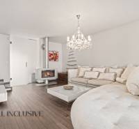 Living room in a family house with a fireplace, sofa, and wooden decor flooring.