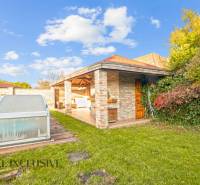 The garden of a family house in Dobrohošť with a covered swimming pool and a gazebo.