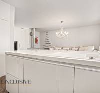 Interior of a family house with a marble counter, chandelier, and floor with a wood decor.