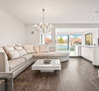 Interior of a family house with a sofa, chandelier, and wooden decor flooring.