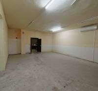 A spacious room in a family house with simple lighting and light-colored walls.