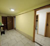 A hallway in a family house with doors and a floor made of ceramic tiles.