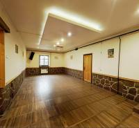 A decorated room with a wooden decor floor, stone, and wooden elements in a family house.