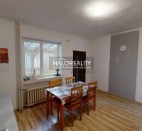 Dining room in a family house with a wood-patterned floor and a table with chairs.