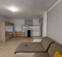 Living room in a family house with a sofa, dining table, and wooden decor flooring.