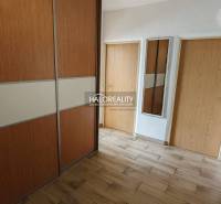 A hallway in a 3-room apartment with a wooden decor floor and a built-in wardrobe.