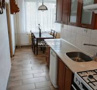 A kitchen in a 3-room apartment with a dining nook and a floor with a wooden decor.