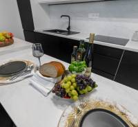 Elegant kitchen in a 3-room apartment with dining, wine, bread, and fruit.