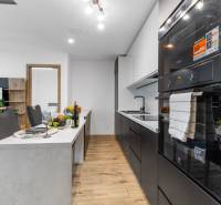 A bright kitchen in a 3-room apartment with a wooden decor floor and modern furnishings.