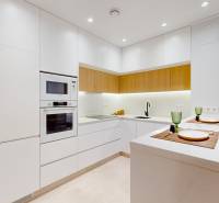 Kitchen area of the Holiday Apartment with white cabinets and integrated appliances.