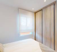 Recreational apartment with a bed, wardrobe, and floor with wooden decor.