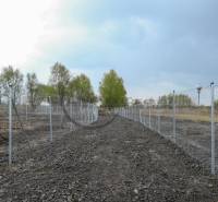 Plots - housing on Nad potokom street in Zohor, fenced area, trees in the background.