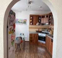 A kitchen in a 3-room apartment with a wooden decor floor and colorful accessories.