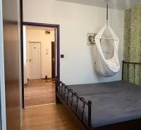 Bedroom with a hanging chair and a bed, floor with wood decor, 3-room apartment.
