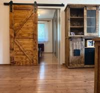Interior of a 3-room apartment with sliding doors and a wooden decor floor.