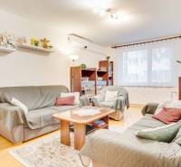 Living room in a 3-room apartment with a wooden decor floor, sofas, and decorations.