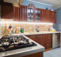 A kitchen in a 3-room apartment with wooden cabinets and patterned tiles.