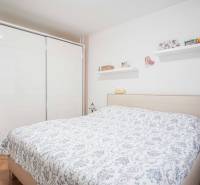 A bedroom in a 3-room apartment with a wooden decor floor, a double bed, and a built-in wardrobe.