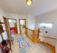 Floor with wood decor flooring, with a staircase and doors to rooms in a family house.
