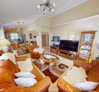Corner leather sofa, glass table, and television in a family house.