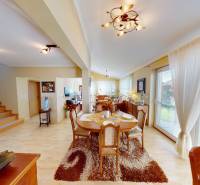 An open dining room with a set table in a family house and a floor with a wooden decor.