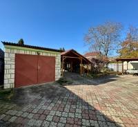 The yard of a family house on Ortášska Street in Nižná Hutka with a garage and a gazebo.
