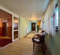 A hallway in a family house with a wooden decor floor and wicker furniture.