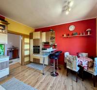 A kitchen in a family house with a wooden decor floor and colorful walls.