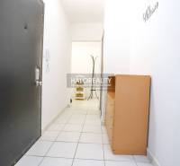 Hallway in a one-room apartment with tiles, a cabinet, and a wall hanger.