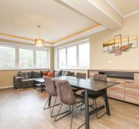 Living room in a three-room apartment with a wooden decor floor and a sofa.