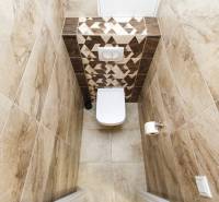 A toilet with modern tiles in a 3-room apartment, neutral color design.