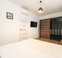 A room with a bed, wardrobe, and television, 3-room apartment, floor with wood decor.