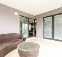 A terrace with rattan furniture and glass doors in a 3-room apartment.