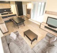 Living room in a three-room apartment with a wooden decor floor and a sofa set.