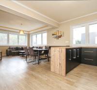 Living room with a sofa, dining table, and wooden decor flooring in a 3-room apartment.