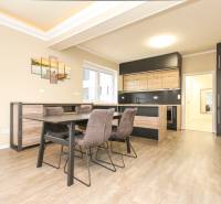 Dining room in a 3-room apartment with a wood-decor floor and a kitchenette.