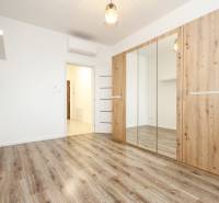 A room in a 3-room apartment with a wood-patterned floor and a built-in wardrobe.