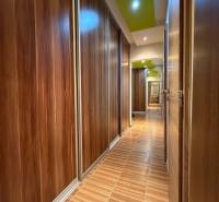 A hallway with cabinets and a floor with a wooden decor in a 3-room apartment.