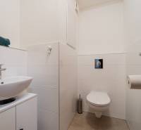 Bathroom with a white sink and toilet in a 2-room apartment.