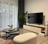 Living room in a three-room apartment with a wooden decor floor and stylish furniture.