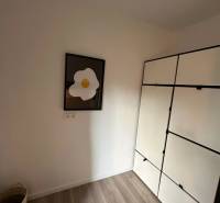 A wardrobe and a painting in a 3-room apartment, floor with wooden decor.