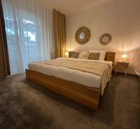 Bedroom in a 3-room apartment with carpet flooring and natural decorations.