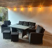 Covered terrace with rattan seating and string lights in a 3-room apartment.