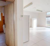 Interior of commercial spaces with light-colored tiles and a bathroom with orange tiles.