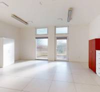 Commercial space with white tiles and cabinets, bright interior.