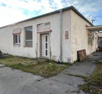 A commercial building on Školská Street in Holíč with damaged facade.
