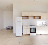 A minimalist kitchen in commercial premises with tiles and appliances.